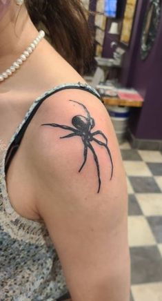 a woman with a spider tattoo on her arm