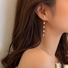 a close up of a person wearing some kind of earring with pearls on it