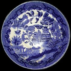 a blue and white plate with an image of a village on it