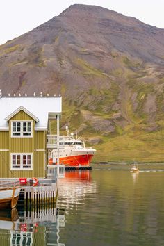 two boats are docked in the water near a mountain