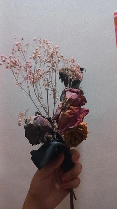 a person holding a bunch of flowers in their hand with the stems still attached to it