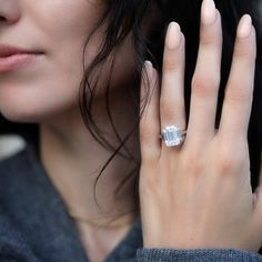 a close up of a person with a ring on their finger and wearing a sweater