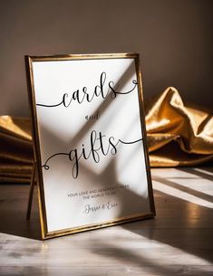 a card and gifts sign sitting on top of a wooden table next to gold shoes