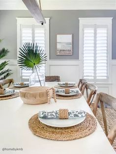 the dining room table is set with place mats and placemats, which are decorated with palm leaves