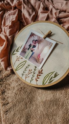 an embroidery project with pictures and thread on the table next to some pink linens