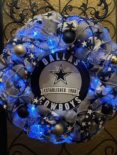 a christmas wreath with lights and decorations on the front door for cowboys fans to decorate