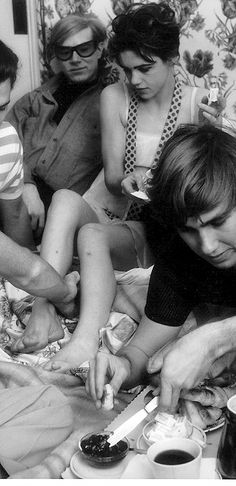 a group of young people sitting on top of a bed next to eachother