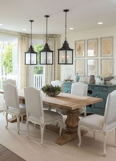 the dining room table is surrounded by chairs and chandeliers with hanging lights above it