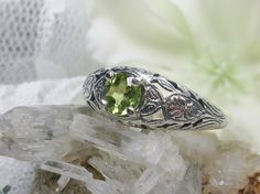 Natural Peridot Ring Etched Wedding Design#160 Made To Order Here we have a Victorian/Edwardian reproduction ring in sterling silver with a stunning natural peridot gemstone. This full cut round peridot gem is 6mm in diameter. The inside of the band is marked 925 for sterling. Notice the beautiful floral design of the silver filigree setting and band. This is a lovely rendition of an Antique filigree ring; and it is ready to wear. A gift ring box is included and all rings are shipped in the box Wedding Ring With Hallmarked Peridot, Green Engraved Wedding Rings, Ornate Green Wedding Ring, Fairy Rings, Garnet Wedding Rings, Filigree Ring Gold, Stock Design, Gemstone Art, Sterling Silver Filigree