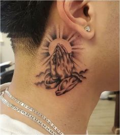 a man with a tattoo on his neck and behind the ear is a praying hand