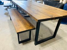 a wooden table with two benches next to it in a room filled with couches