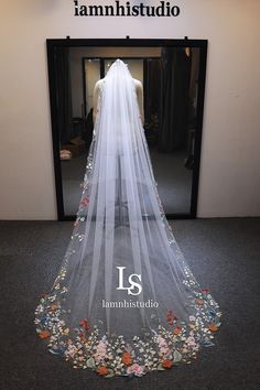 a wedding veil is displayed in front of a mirror