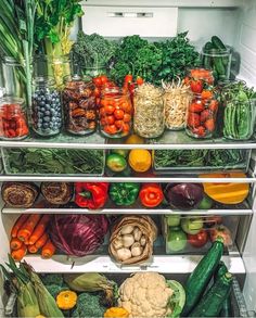 an open refrigerator filled with lots of different types of vegetables