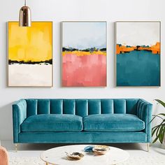 a living room with three paintings on the wall