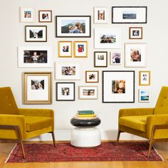 two yellow chairs sitting in front of a wall with pictures on it