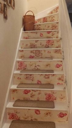 the stairs are decorated with floral wallpaper and carpeted rugs, along with a basket