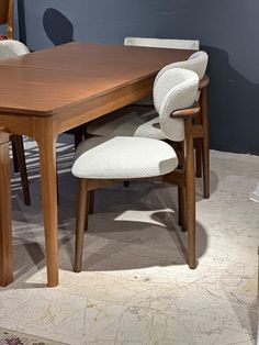 a wooden table with four chairs around it and a rug on the floor next to it