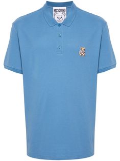 medium blue cotton piqué weave polo collar short sleeves signature Teddy Bear motif short side slits straight hem short front button fastening Versace Sneakers, Moschino Men, City Shorts, Sweatpants Shorts, Summer Beach Wear, T-shirt Polos, Polo Collar, Light Jacket, Mens Polo Shirts