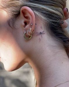 a woman with a cross tattoo on her left ear