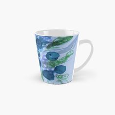 a tall mug with blue flowers and leaves on the inside, in front of a white background