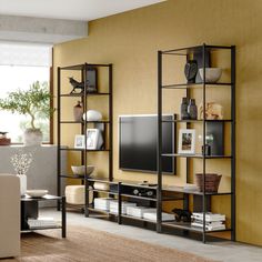 an entertainment center with bookshelves, shelves and a flat screen tv