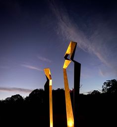 two tall metal sculptures sitting next to each other