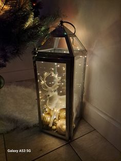 a lighted lantern with christmas decorations on it