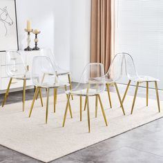 four clear chairs sitting on top of a rug in front of a white table and chair