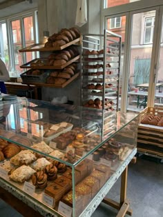 a bakery filled with lots of different types of breads and pastries on display