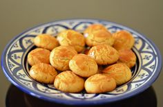 a blue and white plate filled with small cookies