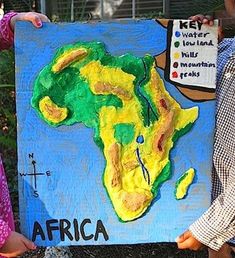 two children holding up a painting with africa on it