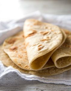 three tortillas sitting on top of a white cloth