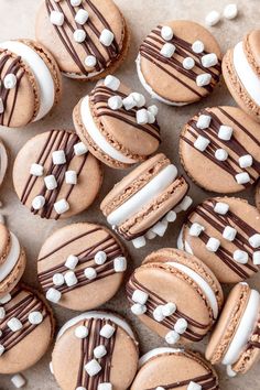 there are many cookies with white and chocolate frosting on them, one is cut in half