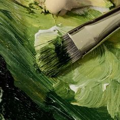 a brush is sitting on top of some green paint