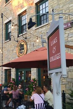 people sitting at tables in front of a building