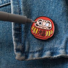 a close up of a button on a person's jean jacket with a pen in it