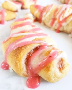 a pastry with icing on it sitting on a white surface next to other pastries