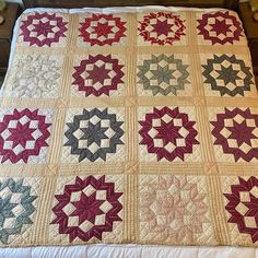 a bed with a quilt made to look like starbursts on the cover