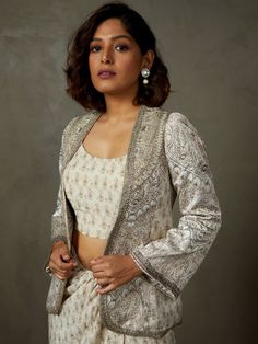 Editor's Note Elevate your style with our grey/off white metal sequence and hand-embroidered vedam jacket, paired with a bustier and a draped skirt. This ensemble exudes a perfect blend of traditional craftsmanship and modern design, making it an excellent choice for special occasions and events, offering a unique and sophisticated look. Color: Gray Fabric: Mushroo dot fabric-light Components: Jacket, skirt and bustier Occasion: Festive Note: Product colour may slightly vary due to photographic Off White Jacket, Ritu Kumar, Grey Jacket, Ancient Designs, Draped Skirt, Dot Fabric, Fabric Light, Gray Fabric, Dotted Fabric