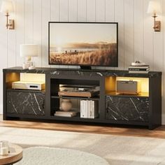 a living room scene with focus on the television and entertainment center, which is decorated in black marble