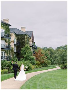 a bride and groom walking down a path in front of an apartment building