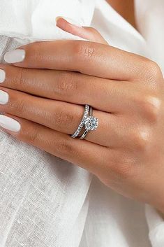 a woman's hand wearing a diamond ring