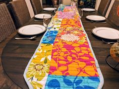 the table is set with plates and place mats on it, which are decorated with colorful flowers