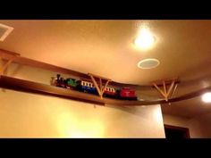 a toy train is sitting on top of a shelf in the corner of a room