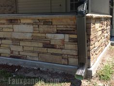 a brick house with a metal gutter attached to the front porch and side wall