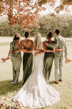 a group of people standing around each other in front of a tree