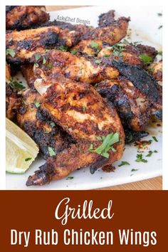 grilled dry rub chicken wings on a white plate with limes and parsley