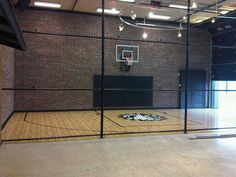 an indoor basketball court with black and white rugs on the floor in front of a brick wall