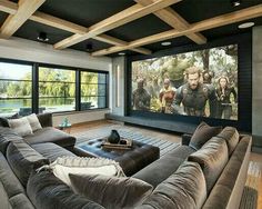 a large living room with couches and a big screen tv on the wall in front of it