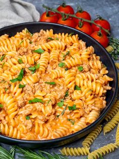 an easy ground turkey pasta recipe in a skillet with tomatoes and parsley on the side